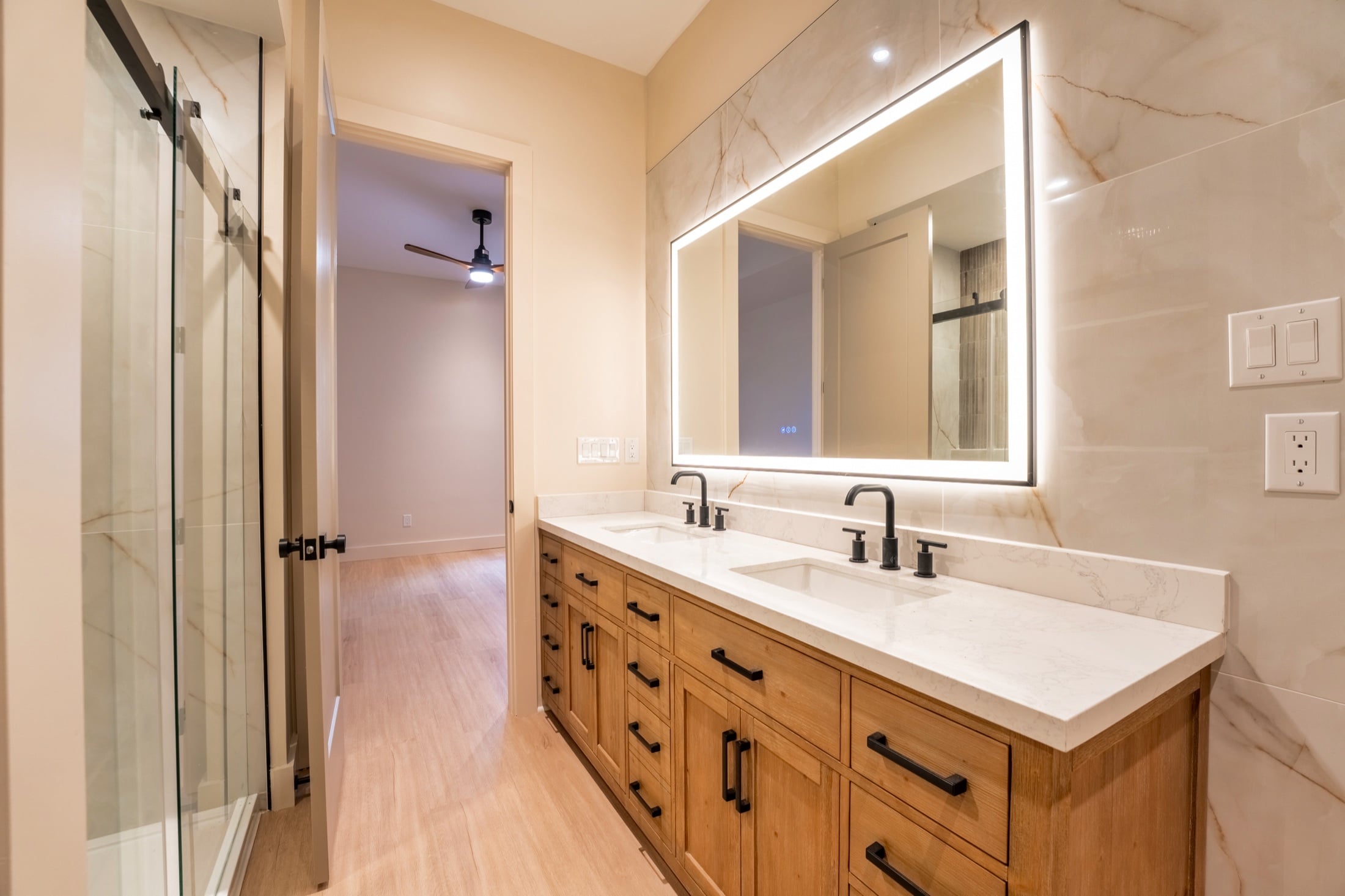 Custom bathroom with double vanity and illuminated mirror built by Built Right Homes